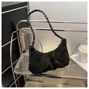 Détail du sac bandoulière noir plissé en similicuir avec une bandoulière tressée chic