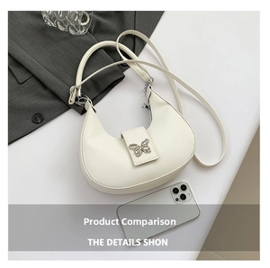 Dettaglio di una borsa hobo bianco crema con una fibbia metallica a farfalla argentata