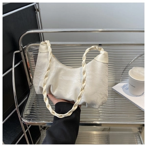 Détail du sac nuage plissé blanc cassé avec une bandoulière tressée au design unique