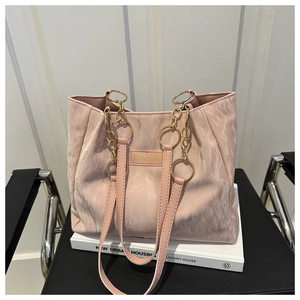 Dettaglio della borsa tote rosa a pieghe con etichetta fashion e catena dorata