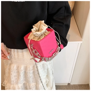 Detailed view of pink cube bag with drawstring interior and silver chain handle