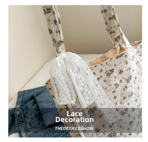 Close-up of floral fabric crossbody bag with delicate white lace bow detail