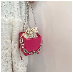 Detail of fuchsia cube bucket bag with silver chain and white drawstring liner