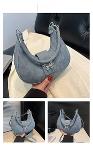 Dettaglio della borsa hobo grigio-blu con trama opaca e fibbia a farfalla argentata