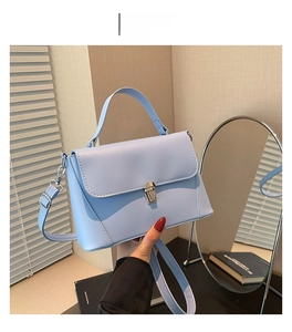Detail of light blue PU leather handbag with silver buckle and detachable shoulder strap