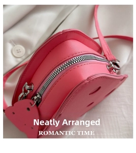 Dettaglio macro della borsa a triangolo rosa in pelle PU con zip argento e tracolla