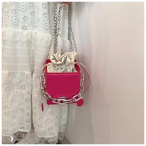 Detail of rose red bucket bag with drawstring liner and chunky silver chain strap