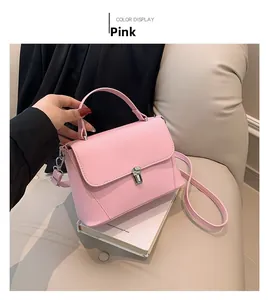Detail of light pink crossbody bag featuring smooth matte leather and silver metal buckle
