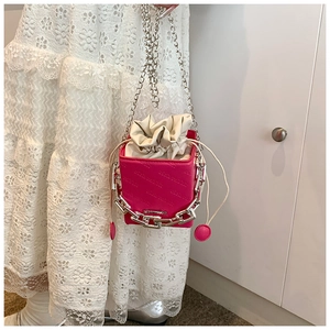 Close-up of fuchsia box bag with Rich Rabbit embossing and bold silver metal chain detail