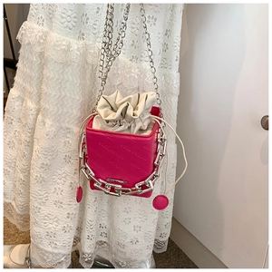 Detailed view of rose red box bag with chunky silver chain and drawstring interior