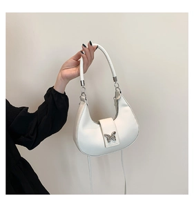 Détail du sac hobo en cuir PU blanc avec boucle en métal argenté en forme de papillon