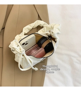 Top view of white ruched crossbody bag interior showing spacious storage for phone and makeup