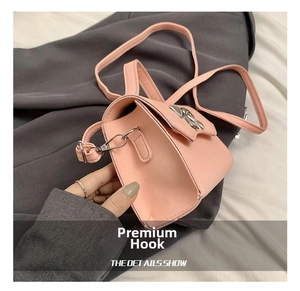 Detail of silver metal hook and pink leather strap on a small crossbody bag