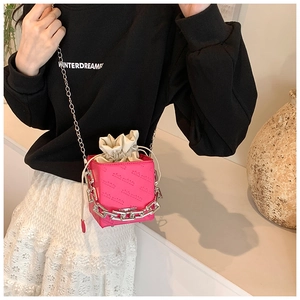 Detail of bright pink embossed cube bag featuring a silver chunky chain and drawstring