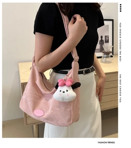Détail de texture du sac hobo plissé rose avec un charmant pendentif chiot en peluche