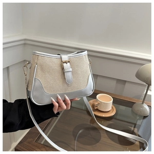 Detail of beige woven canvas handbag with metallic silver trim and buckle closure