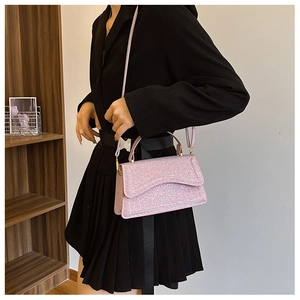 Detailed side view of pink sequin crossbody bag on model showing size and texture