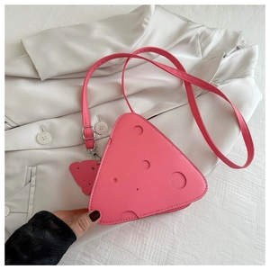 Dettaglio della borsa a tracolla rosa a forma di formaggio con design a fori unico