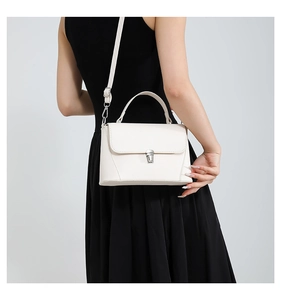 Detailed back view of a white minimalist shoulder bag with a silver lock on black dress