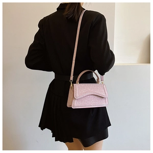 Detail of pink sequin crossbody bag showing its shimmering texture and compact square shape