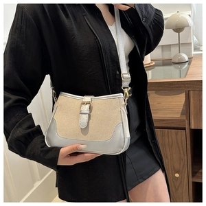 Detail of minimalist beige canvas and silver PU leather shoulder bag with buckle