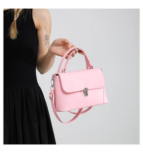Pink top-handle bag with silver metal buckle closure and detachable shoulder strap detail