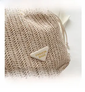 Detailansicht der Stroh-Eimertasche mit weißem Leder-Patch und praktischem Kordelzug