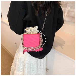 Detail of fuchsia leather mini box bag with silver chain and rich rabbit embossed texture