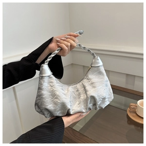 Détail d'un sac hobo argenté avec texture froissée et anse torsadée métallique