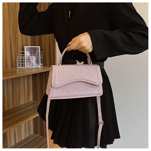Detail of pink sequin handbag with gold hardware and adjustable shoulder strap