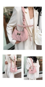 Detail of pink pleated crossbody bag featuring bow shoulder straps and butterfly metal charm