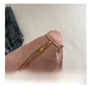 Gros plan sur la fermeture éclair en métal doré d'un sac cabas rose au fini brillant