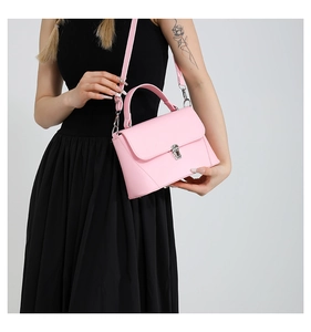 Detail of light pink shoulder bag with silver metallic rotary lock and textured PU leather