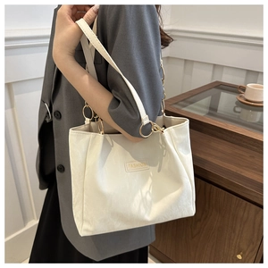Borsa tote bianca minimalista con trama in ecopelle e dettagli di anelli in metallo dorato sui manici