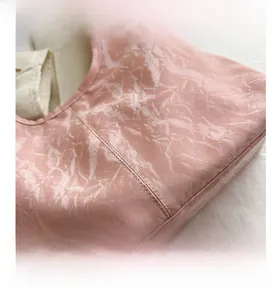 Gros plan du sac à main rose marbré montrant les détails de couture et les plis du cuir