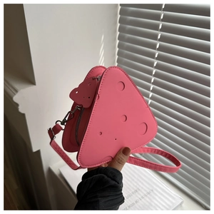 Dettaglio della mini borsa rosa in pelle PU a forma di formaggio con charm orsetto
