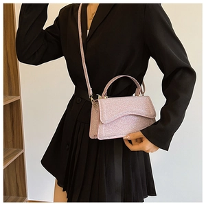 Close-up of pink sequin handbag featuring gold metal buckles and a shimmering finish