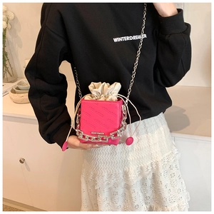 Macro detail of rose pink crossbody bag with silver chain and white drawstring liner