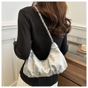 Détail du sac à bandoulière argenté plissé avec texture métallique et sangle tressée