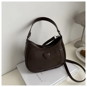 Detail of dark brown crescent bag with embossed heart and silver metal hardware