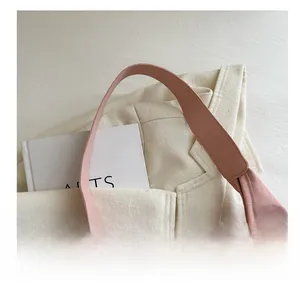 Détail de la bandoulière large du sac rose et coutures de qualité sur un costume beige