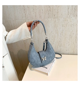 Détail du sac hobo en jean bleu clair avec délavage vintage et boucle papillon argent