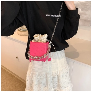 Detail of rose pink box bucket bag featuring embossed leather and silver chunky chain