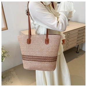 Detailed shot of large woven tote bag with brown leather handles and summer style texture