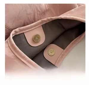 Détail du sac à main rose à texture froissée montrant le fermoir magnétique en métal