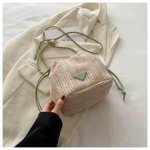 Detail of woven bucket bag featuring mint green drawstring and triangle logo patch