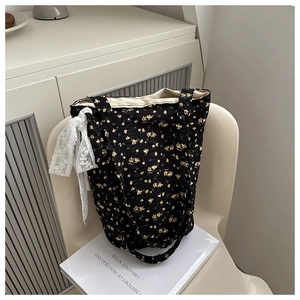 Detail of floral tote bag with white lace bow on a minimalist chair background