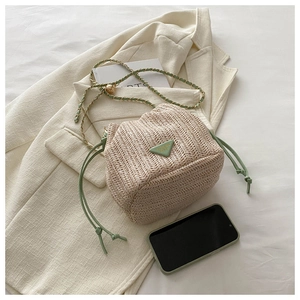 Detailed straw bucket bag with green drawstring and elegant triangular emblem