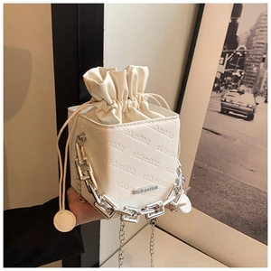 Detail of white cube box bag showing rich rabbit embossed pattern and metal chain handle