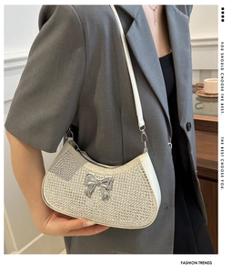 Close-up of hobo shoulder bag with sparkling rhinestones and a metal bow detail